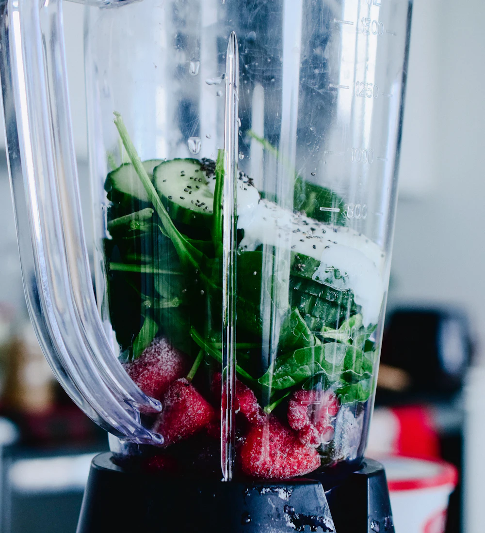 Spinach, berries and cucumber in a blender