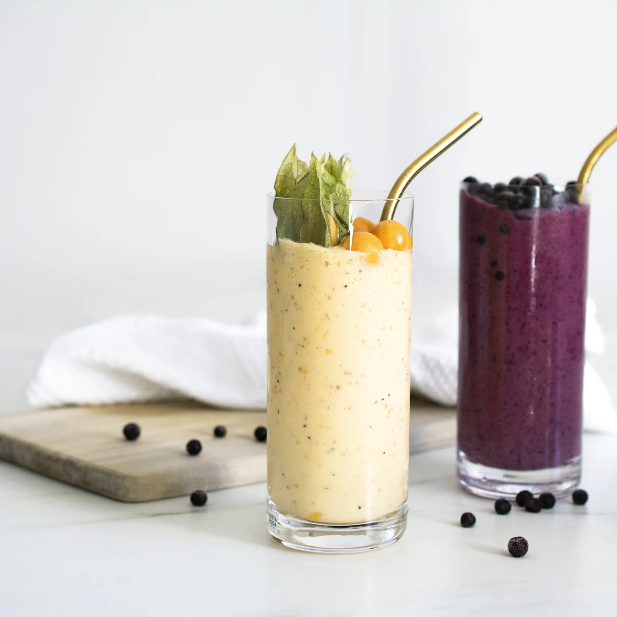 Two colourful smoothies with straws